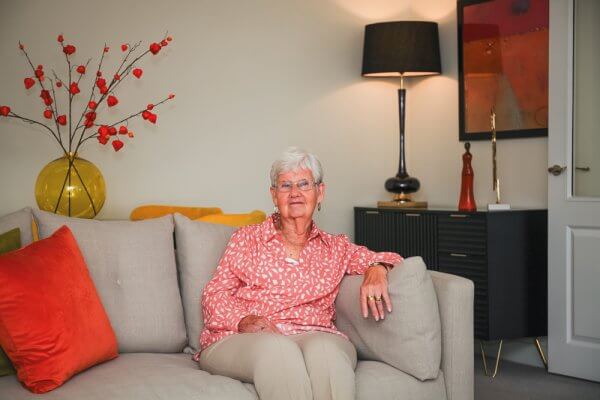 Margaret relaxing on the sofa in an elegantly dressed Adlington Apartment