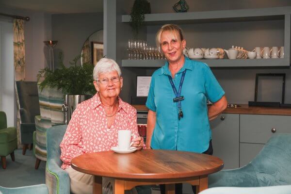 Homeowner Margaret in the homeowners lounge with a member of staff