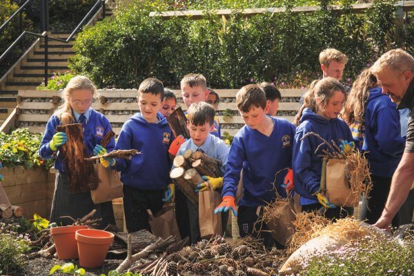 Children selecting materials to use in creating a bug hotel