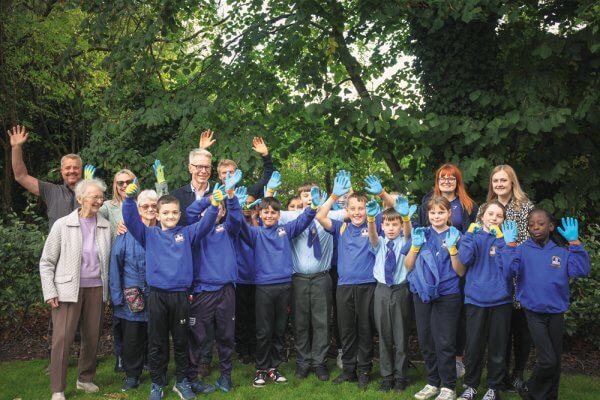School children visiting Brookfields House celebrating the day with a cheer wearing gardening gloves