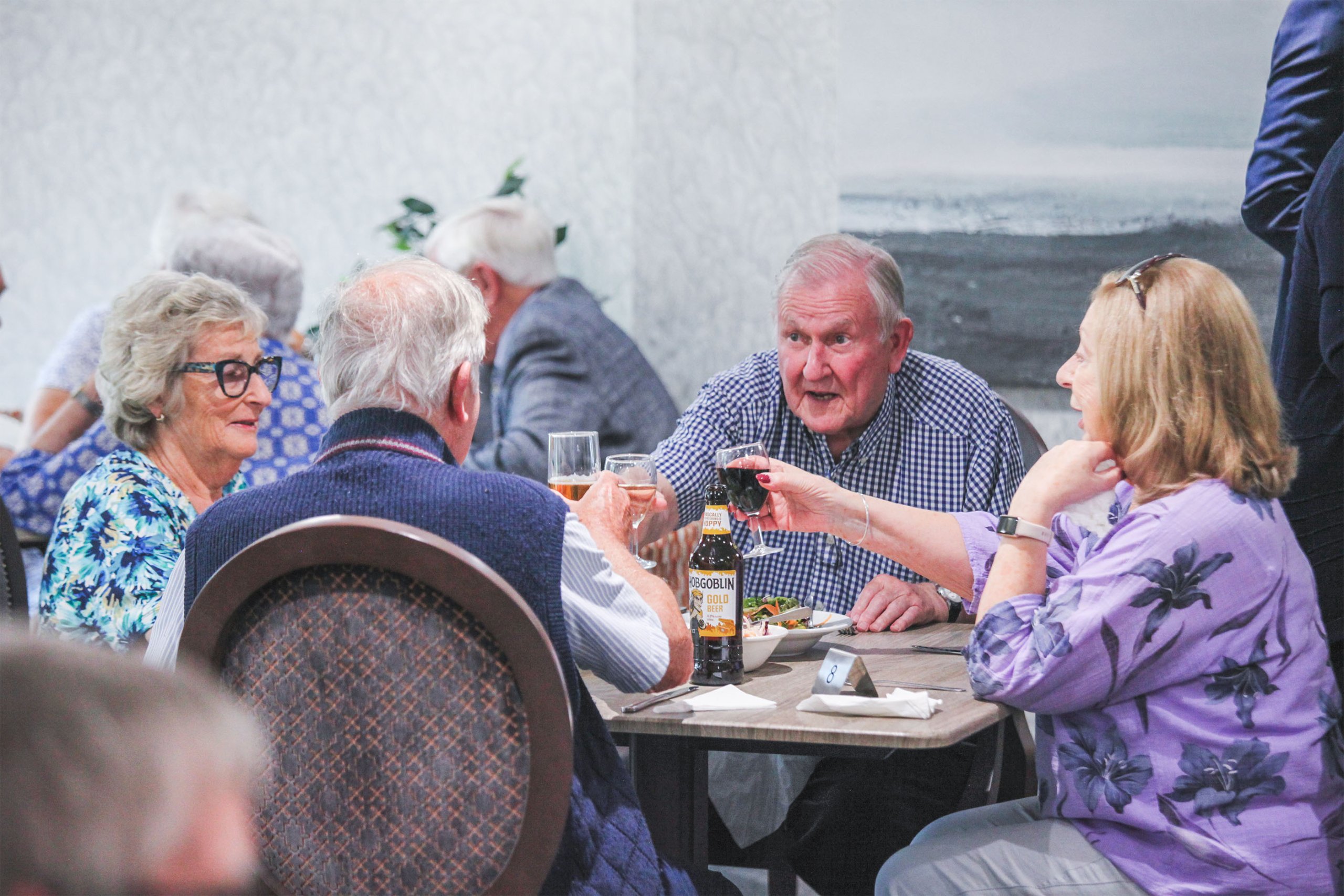 A group of homeowners, including Tony, cheering and raising glasses at an Adlington event.