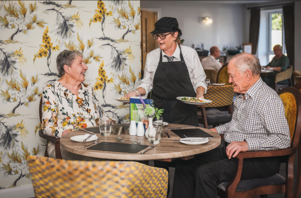 Homeowners Maura and David being served a meal in the onsite restaurant