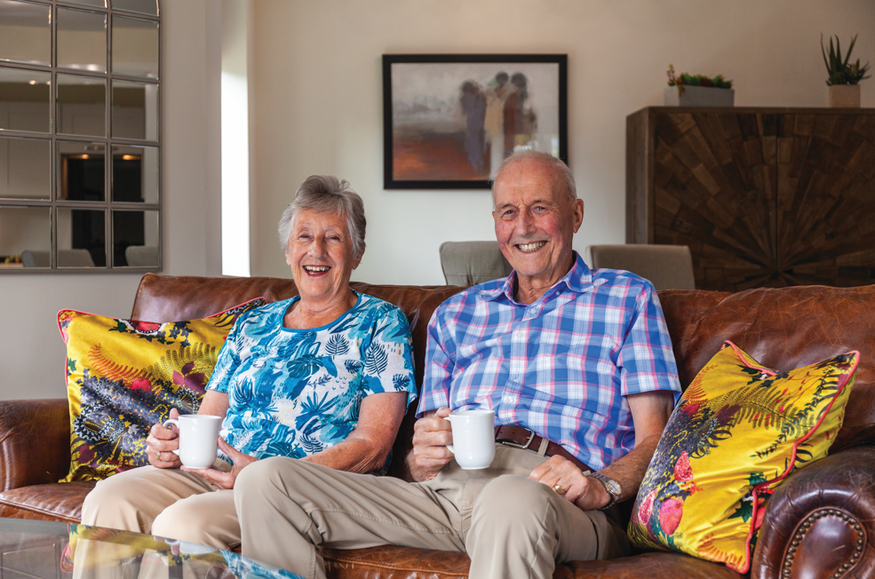 Magaret and Keith sat in thair Adlington retirement living apartment with a cup of tea